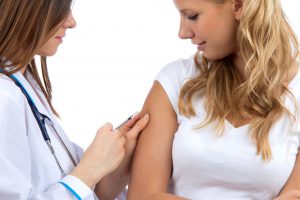 female doctor giving female patient flu shot