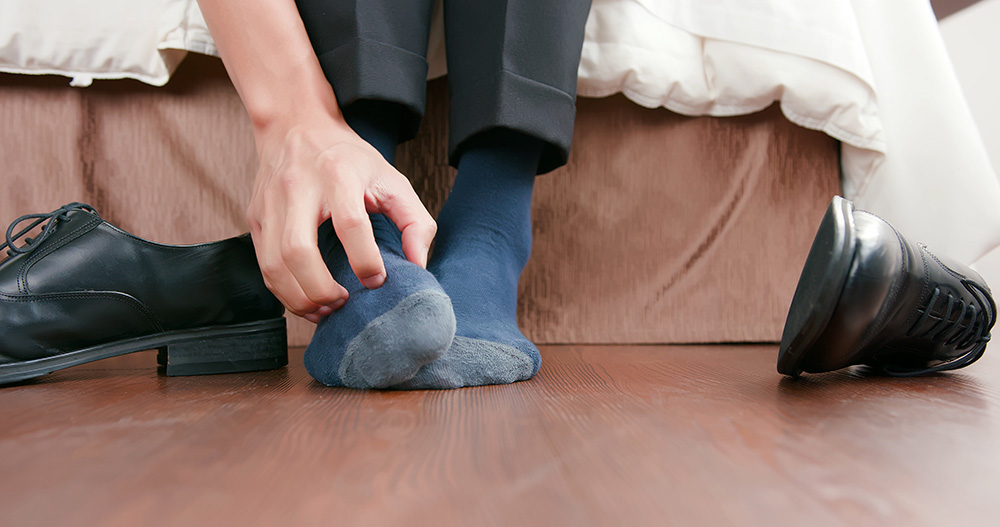 Close up of a man scratching his foot.